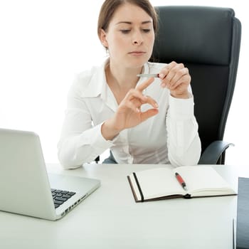 young brunette business woman file nails while working