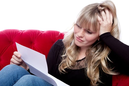 young blond haired girl on red sofa got bad news in front of white background