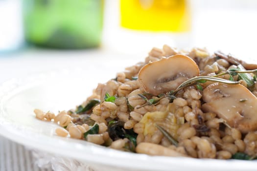 Healthy vegan barley dish with mushrooms collard greens, thyme and rosemary.