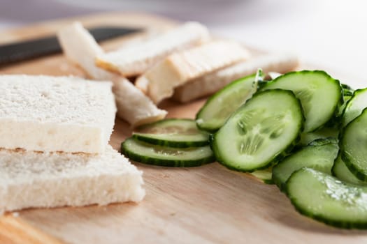 White bread with crust cut off and cucumbers to make cucumber sandwiches for afternoon tea