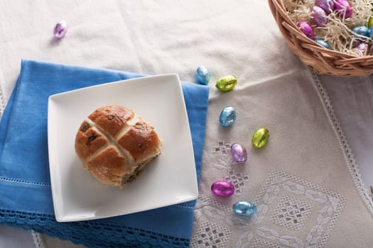 Hot cross bun from above with chocolate easter eggs