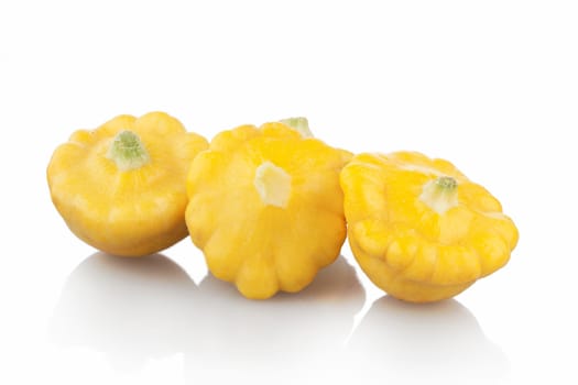 Three pattypan squash on white background with shadows