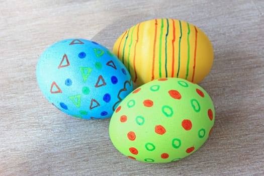 brightly colored Easter eggs on old,gray wooden board