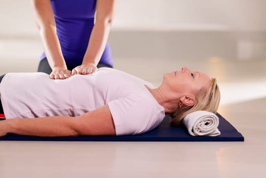 Alternative traditional medicine and massage, young spirit healer doing reiki treatment to old woman. Waist up, copy space