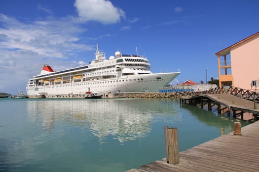 Cruise ship docked in St. John’s Harbour in Antigua Barbuda with copy space in the sky and on the water.