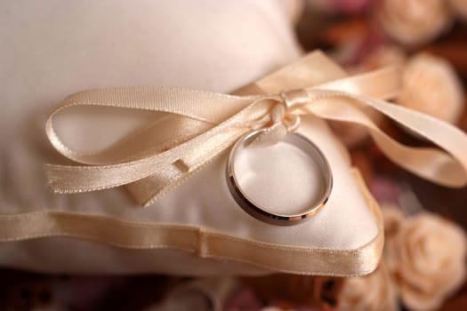 Golden wedding ring on small pillow