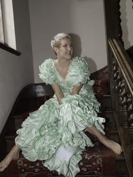 Girl on stairs ready for the party wearing a ball gown