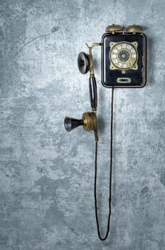 Antique telephone on a blue weathered wall