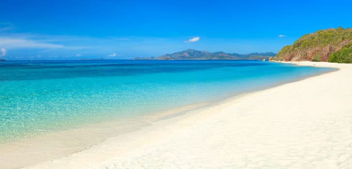 Tropical sandy beach Malcapuya at summer sunny day. Panorama