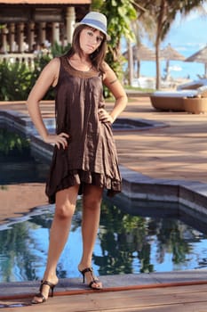 Beautiful Young woman poses beside the swimming  pool