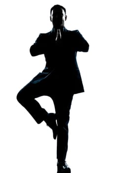 one caucasian business man yoga tree pose  full length silhouette in studio isolated white background