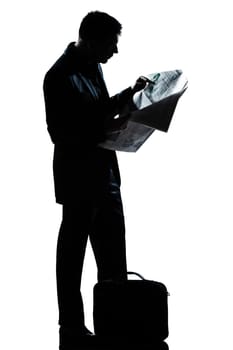 one caucasian man standing reading newspaper  full length silhouette in studio isolated white background