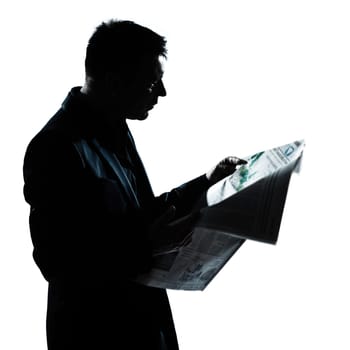 one caucasian man portrait silhouette reading newspaper in studio isolated on white background