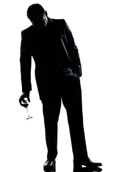 one caucasian man full length silhouette  drunk holding a glass of red wine in studio isolated white background