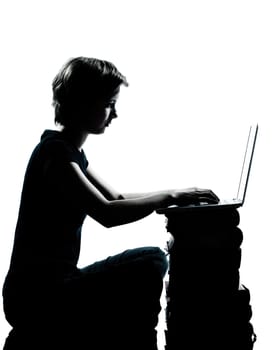 one caucasian young teenager silhouette boy or girl sitting computer computing laptop books full length in studio cut out isolated on white background