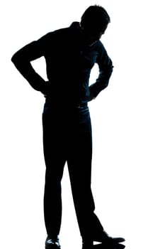one caucasian man  looking at his shoes full length silhouette in studio isolated white background