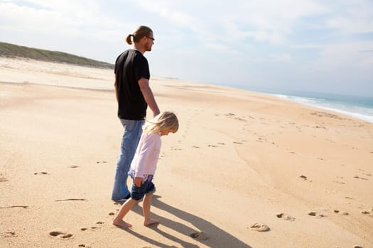 Father and young daughter spending holiday time together at beach in Portugal