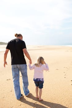 Father and daughter spending holiday time walking together at beach in Portugal