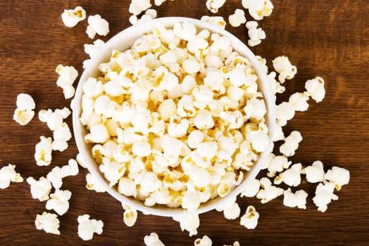 Popcorn in bowl on wooden table
