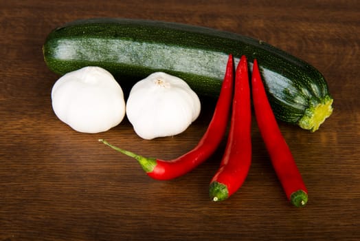 Zucchini, garlik and red hot chilie peppers on kitchen table