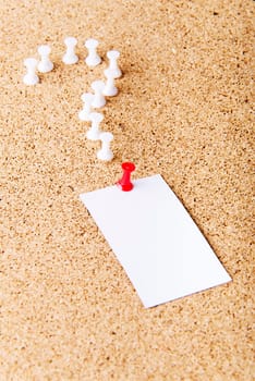 Note paper on cork board with question mark.