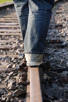a person balancing on a railway track, danger