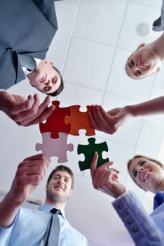 Group of business people assembling jigsaw puzzle and represent team support and help concept