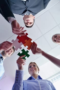 Group of business people assembling jigsaw puzzle and represent team support and help concept