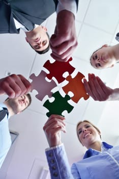 Group of business people assembling jigsaw puzzle and represent team support and help concept