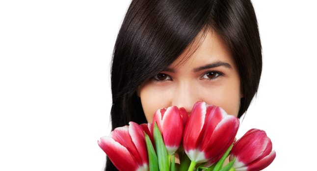 Beautiful young woman smelling a bunch of fresh red tulips