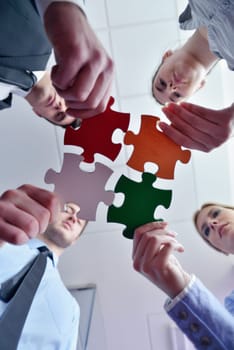 Group of business people assembling jigsaw puzzle and represent team support and help concept