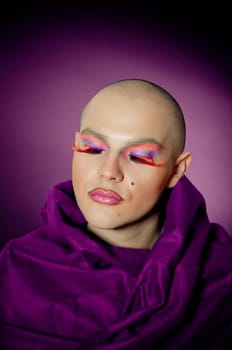 Handsom man with drag makeup on violet background