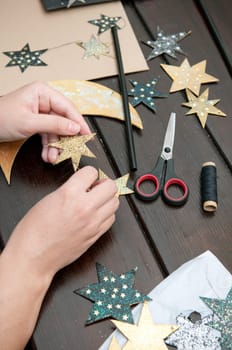 Woman hands crafting cardboard mobile