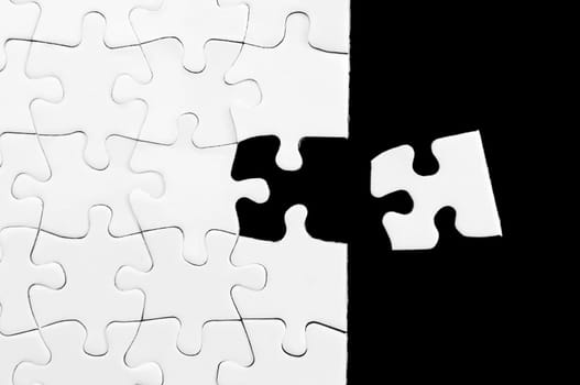 Blank white puzzle with missing piece. Black background.