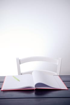 Empty chair and blank notebook on the table