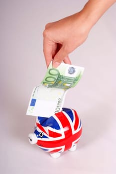 Piggy bank with UK flag and 100 euros