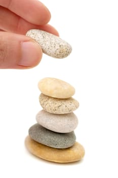 Man stacking pebbles. Isolated on white.