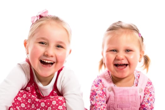 studio shot of two laughing sisters