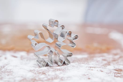 Closeup of star shaped gingerbread dough cutter on kitchen table