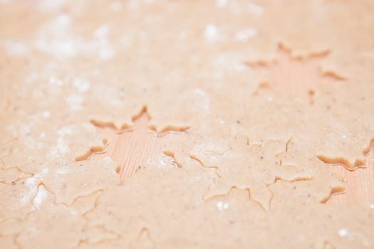 Closeup of gingerbread biscuit dough with star shapes