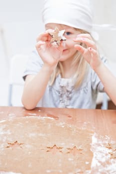 Young girl showing star shaped gingerbread dough piece