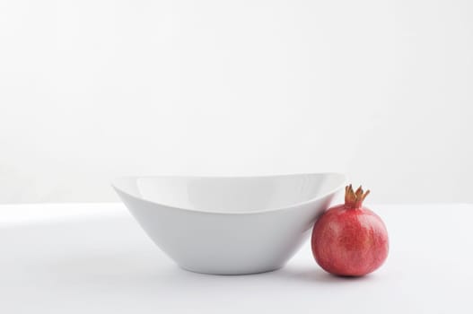White china bowl and pomegranate
