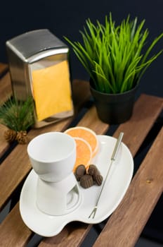 China fondue set and orange slice on wooden table
