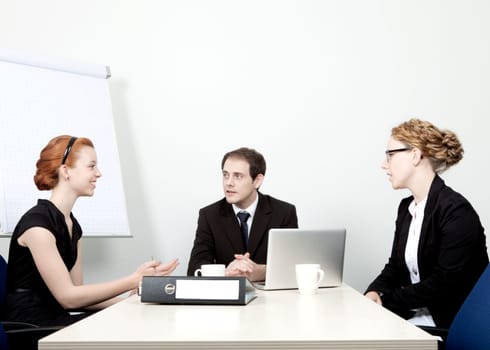 Successful attractive young business team having a meeting seated around a table having an animated discussion as they plan their future strategy