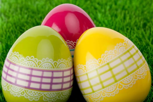 Three traditional decorative Easter eggs on grass, close up