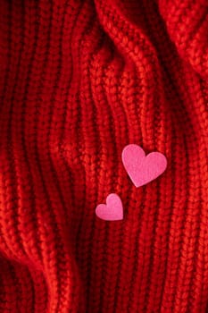 Decorative pink heart on a red knitted background, top view. Place for an inscription