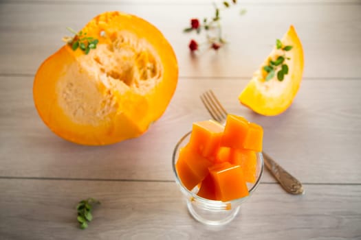 Prepared sweet pumpkin marmalade in a glass bowl on a wooden table. Autumn recipes.