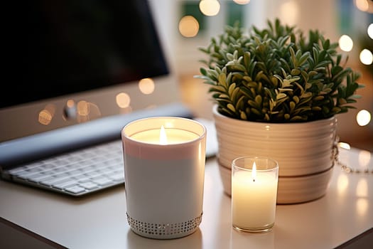 some candles and a plant on a table with a computer in the back ground behind it is a white keyboard