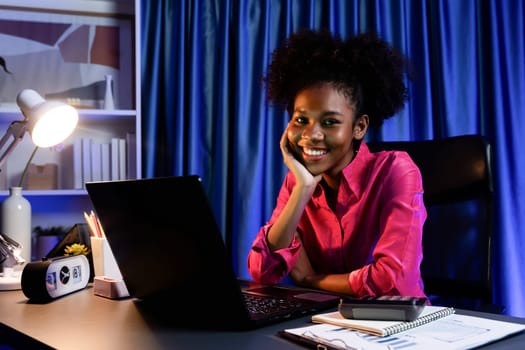 Working African woman with happy glowing, smiling face, getting new job project with good deal or marketing course scholarship information on laptop screen. Concept of cheerful expression. Tastemaker.