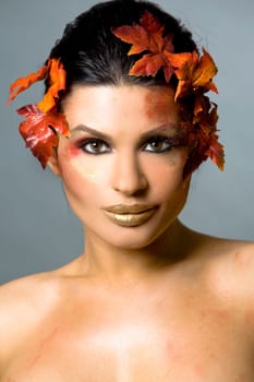 pretty brunette woman wearing leaves and colorful makeup